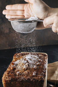 Woman pouring powdered sugar on pumpkin pie