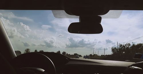 Car on road against cloudy sky