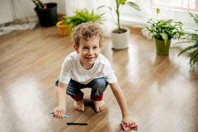 High angle view of boy playing on wooden floor