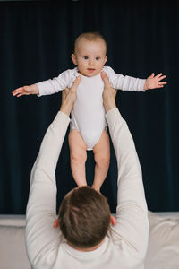 Baby smile when his father picks him up in his arms and lifts him up