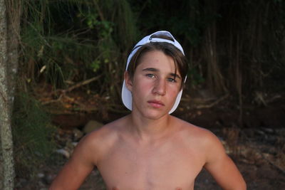 Portrait of teenage boy standing at lakeshore