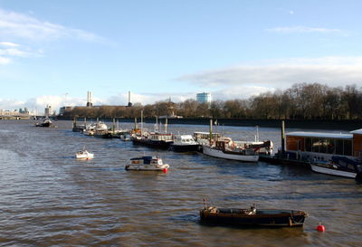 Sailboats moored on river against sky