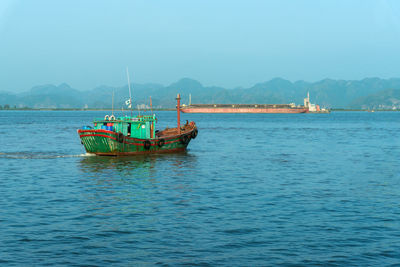 Boat sailing in sea against sky