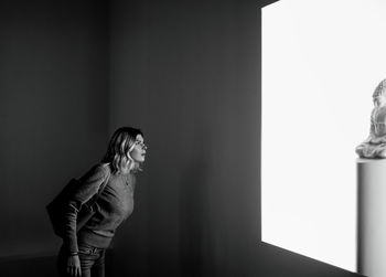 Woman standing against wall at home