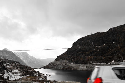 Scenic view of sea and mountains against sky
