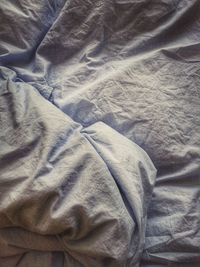 High angle view of crumpled white sheet on bed