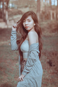 Portrait of young woman standing on field