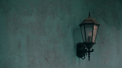 Close-up of electric lamp hanging on wall