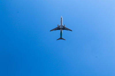 Directly below shot of airplane flying against clear blue sky