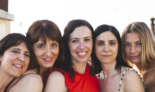 Close-up portrait of female friends against clear sky