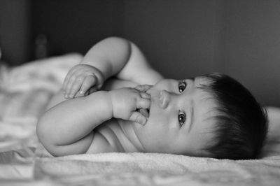 Portrait of cute baby lying on bed at home