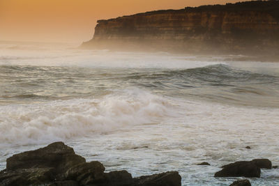 Scenic view of rocks in sea against sky