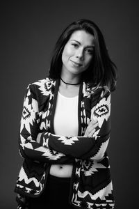 Portrait of smiling woman against black background