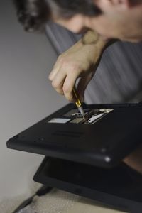 Cropped image of man holding paper on table