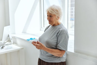 Senior woman standing by window