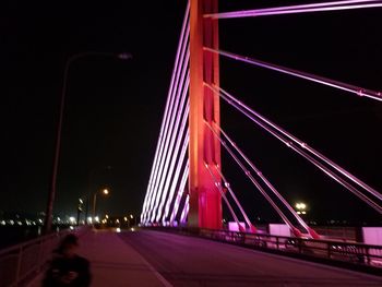 Illuminated suspension bridge against sky at night