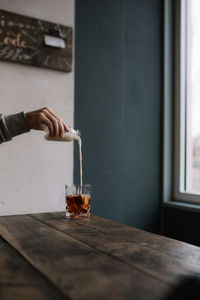 Person holding glass on table