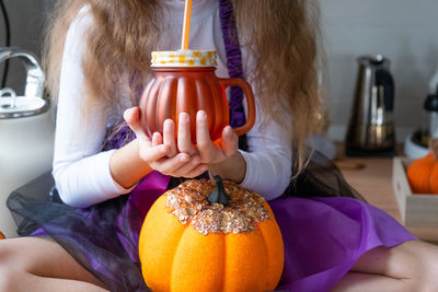 Midsection of woman holding pumpkin