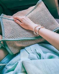 Midsection of woman with purse sitting in car