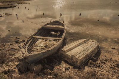 Abandoned boat moored on shore