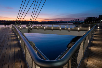 Bridge over sea against sky during sunset