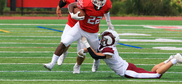 A football player is being tackled by another player.