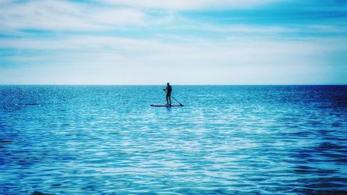 Man surfing in sea against sky