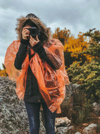 Full length of photographer photographing outdoors