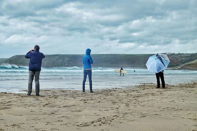 People on beach against sky