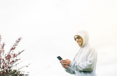 Man using smart phone against sky