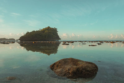 Rocks in sea against sky