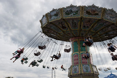 Low angle view of people enjoying chain swing ride