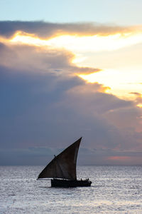 Sailboat on sea against sky during sunset