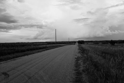 Road amidst field against sky