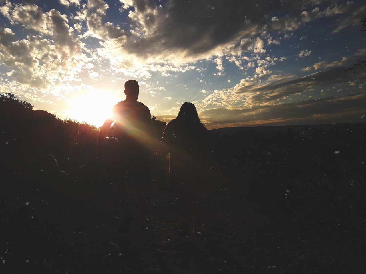 sunset, sunbeam, sun, silhouette, sky, sunlight, lens flare, cloud - sky, real people, nature, leisure activity, outdoors, one person, beauty in nature, scenics, landscape, men, lifestyles, standing, day, people