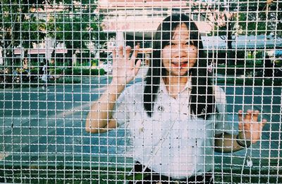 Portrait of young woman in cage