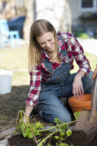 Young woman planting plant, stockholm, sweden