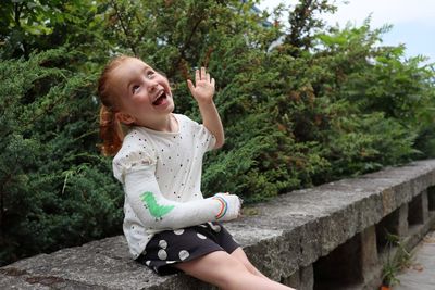 Smiling girl sitting by plants