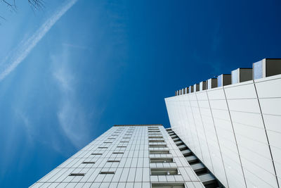 Low angle view of modern building against blue sky