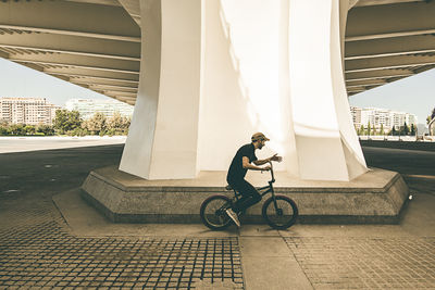 Man riding bicycle on bridge