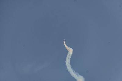 Low angle view of airplane flying against blue sky