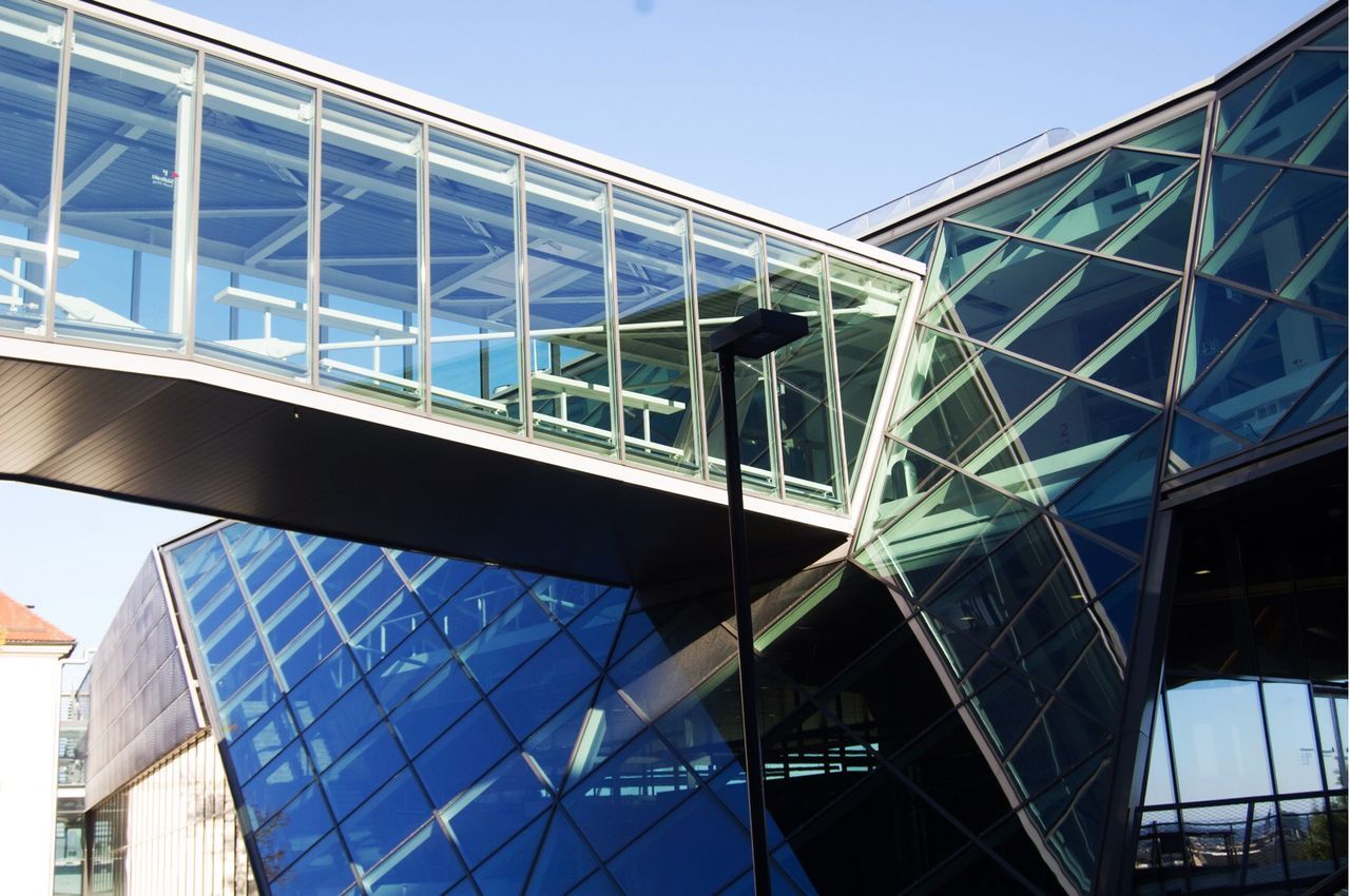 LOW ANGLE VIEW OF MODERN SKYSCRAPER AGAINST CLEAR BLUE SKY