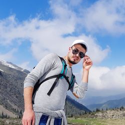 Young man standing against mountains