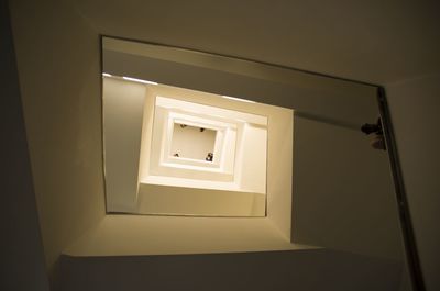 Low angle view of people seen through spiral staircase