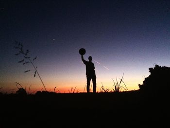 Low angle view of silhouette man standing against clear sky