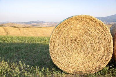 Hay bales on field against sky