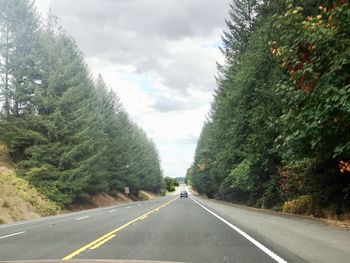 Road amidst trees against sky