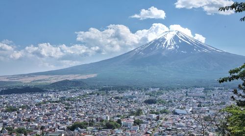 Aerial view of townscape and mountains against sky