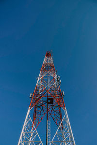 Low angle view of communications tower against clear blue sky