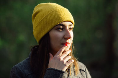 Close-up portrait of young woman wearing hat